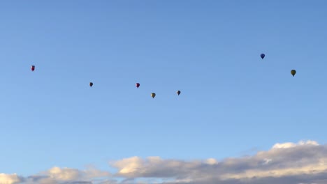 group of seven hot air balloons flying high in the sky