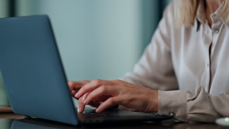 mujer seria trabajando en la computadora en la oficina retrato. manos del gerente escribiendo portátil