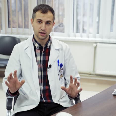 doctor talking on camera in clinic. family therapist in white coat giving a medical consultation online in medical center.
