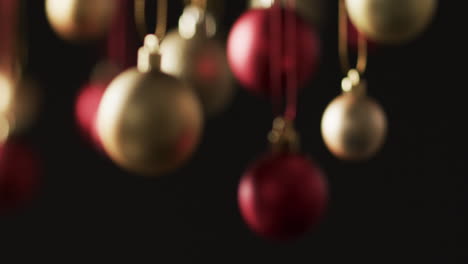 video of gold and red baubles christmas decorations with copy space on black background