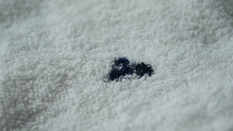 close-up of a white towel with a small blue embroidered mark
