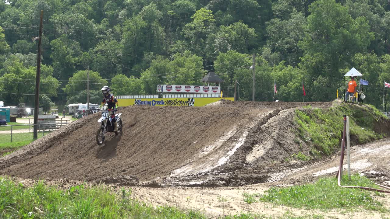 Pilotos de motocross pulando com motos de cross em uma pista de lama