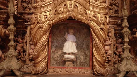 baroque style shrine with a sacred infant statue in an elaborate golden altar