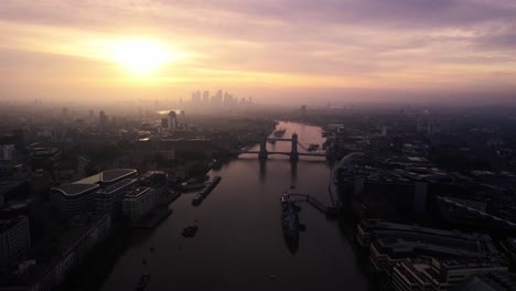 bird's aerial drone view of majestic tower bridge in thames river, london, uk, sunset