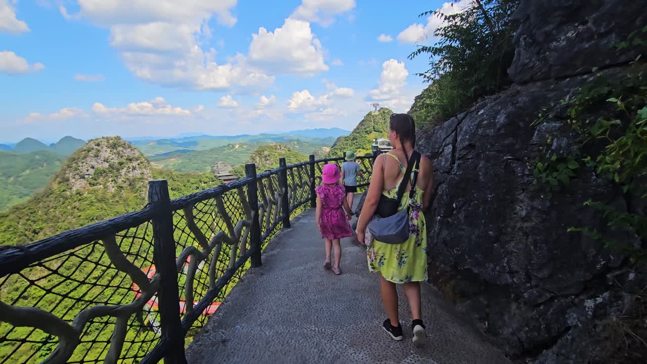 POV shot of a family walking on a scenic walkway at Ruyi Peak, in Yangshuo, China