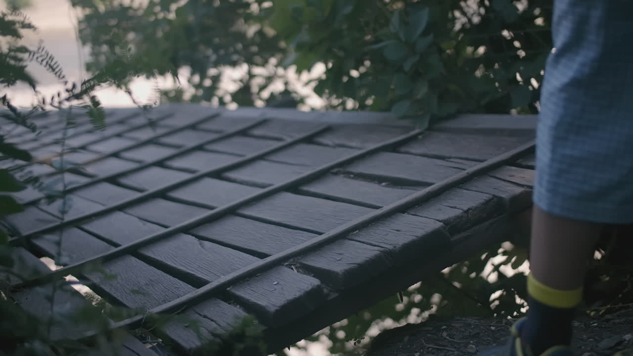 오래된 나무 다리 위를 고 있는 아이