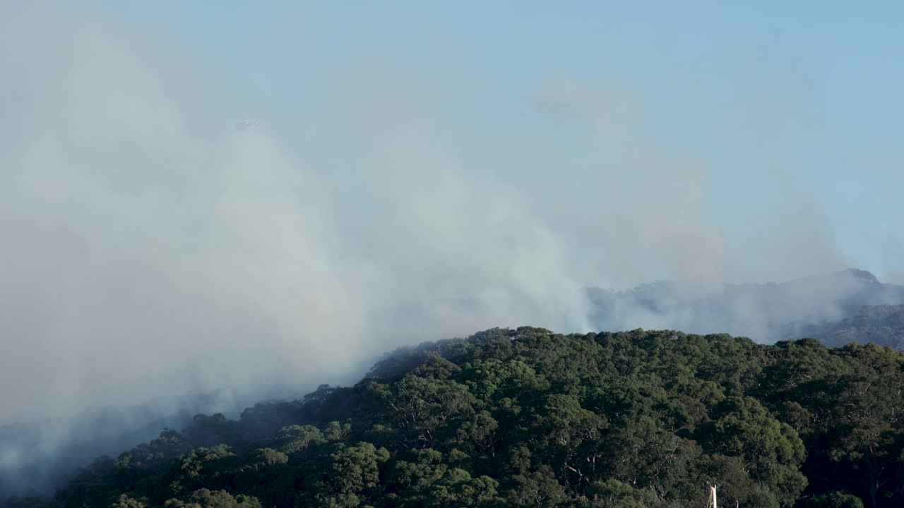Helicopter hover over Back burning fire El Niño 4K footage captures back burning, firefighting, smoke and helicopter rescues. May 29, 2023 Sydney Australia