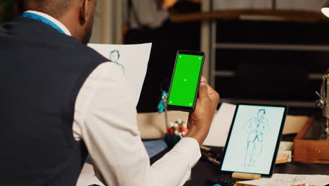 sastre usando pantalla verde en el taller