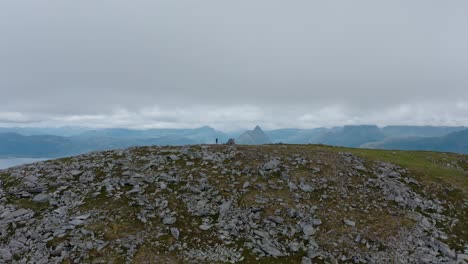 excursionista de pie en la cima de la montaña rocosa en luroy, condado de nordland, noruega
