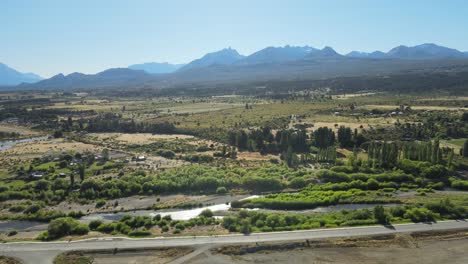 aerial flying over trevelin valley with pine tree woods and mountains in background, patagonia argentina