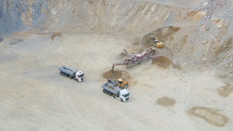 Heavy machines extracting and crushing stones
