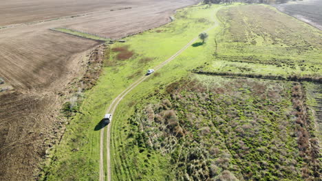 Drone-Shot-chasing-tow-cars-crossing-the-Farmland-on-a-sandy-road-Istanbul,-Turkey