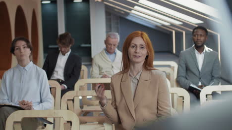 red-haired female journalist asking question during news conference