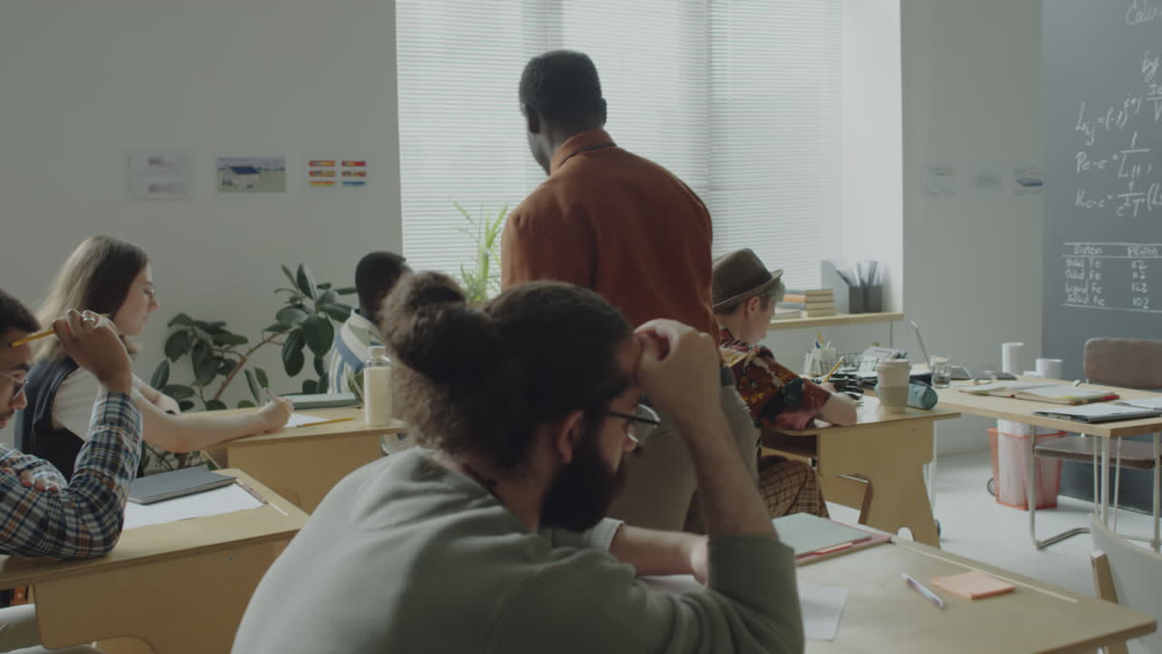 A teacher supervises students in a diverse classroom setting