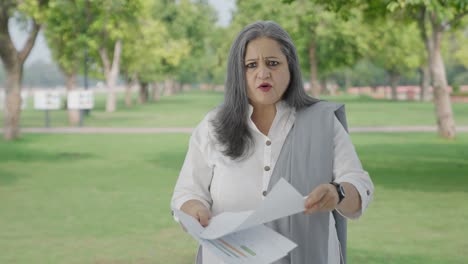 Angry-Old-Indian-woman-discussing-reports-in-park