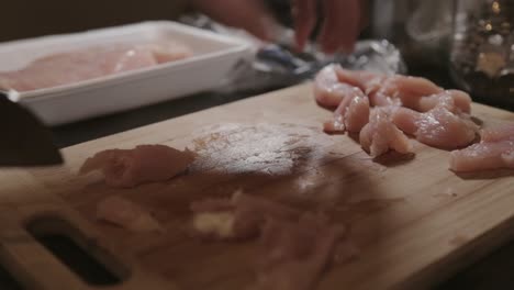 slicing the chicken meat into thin strips using a sharp kitchen knife - close up shot