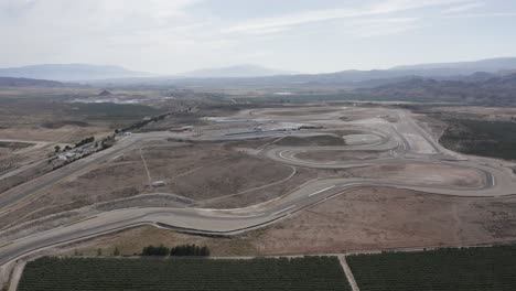 paisaje montañoso polvoriento con una pista de carreras en el medio