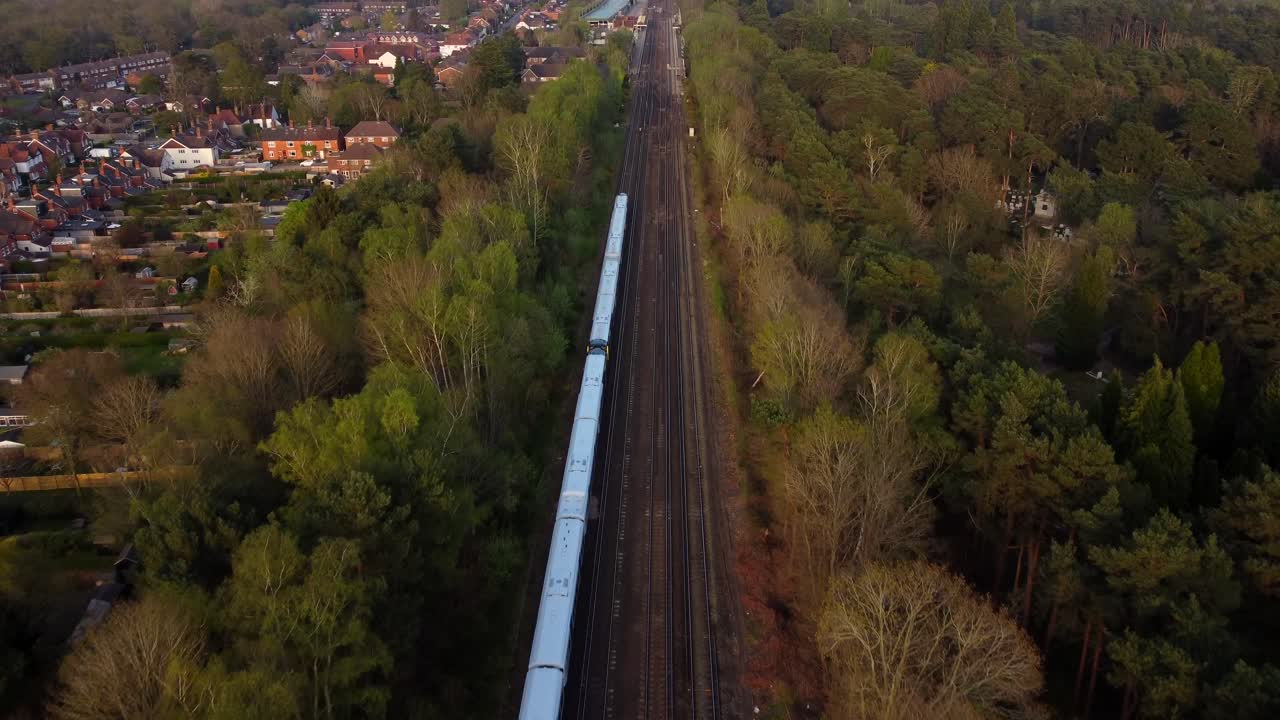 tren de vista aérea que viaja a través de la campiña inglesa en un día soleado
