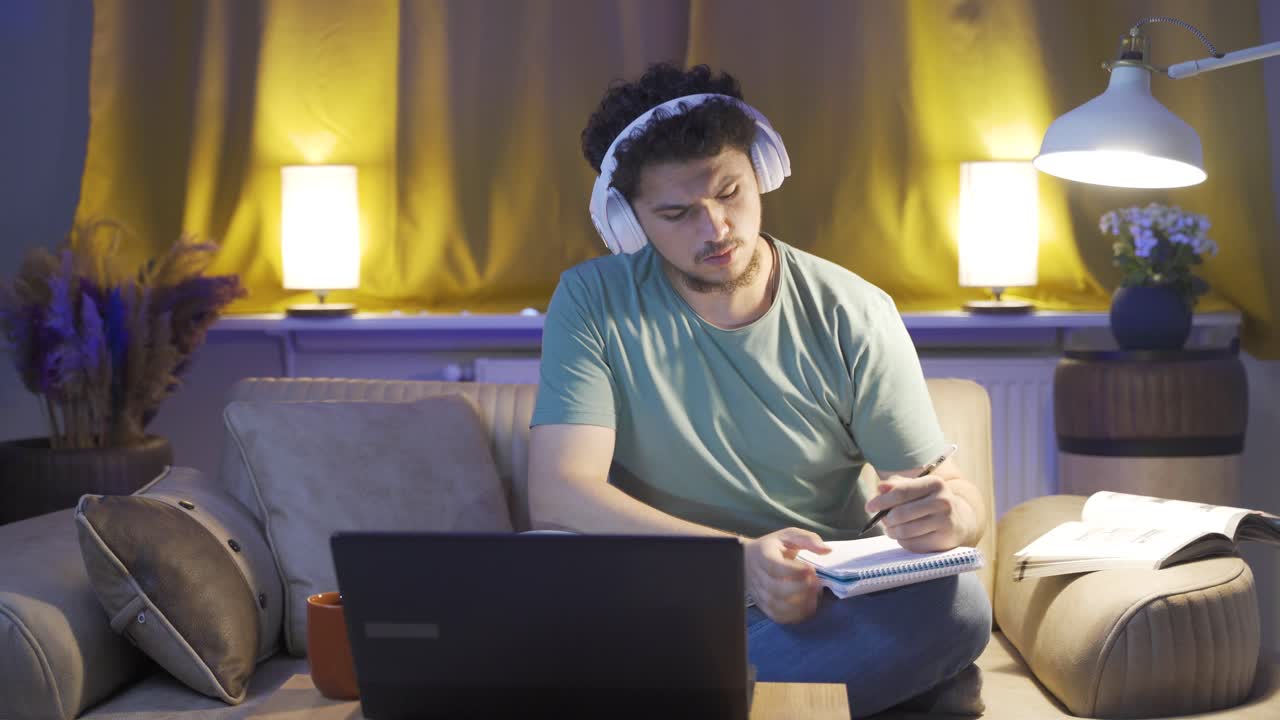 Estudiante escuchando música y estudiando por la noche