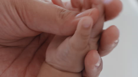 de cerca la madre sosteniendo al bebé con la mano tocando los dedos la madre cuidando al recién nacido cuidando del bebé en casa el amor de la maternidad 4k