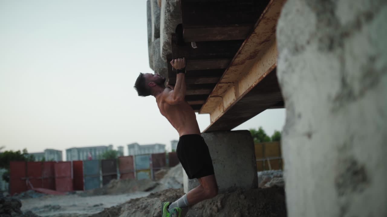 hombre calentándose en la calle trabajando en pull ups
