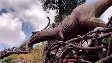 low angle view of life-size models of dinosaurs standing tall in a volcanic park in orizaba, puebla, mexico.