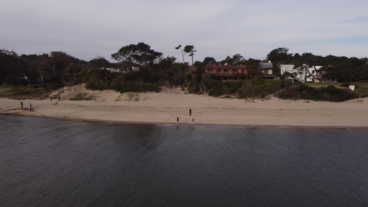 toma aérea de dos niños jugando en la playa de arena en el río maldonado en uruguay