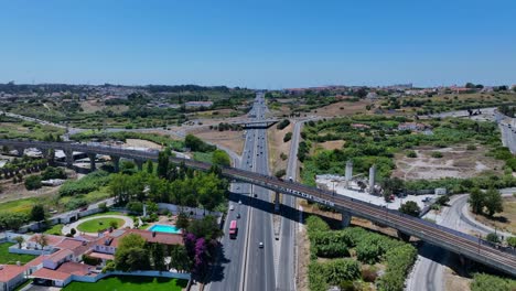 drone shot of a traintrack bridge that goes over a highway