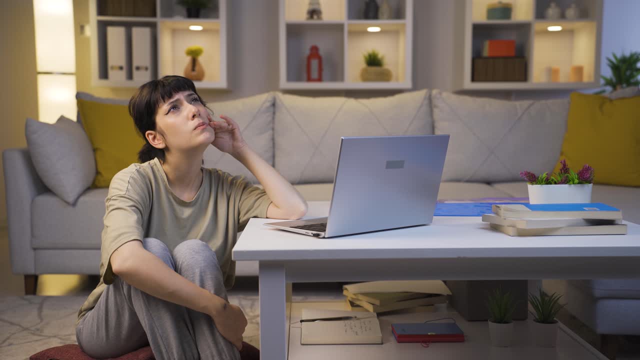 젊은 여성이 집에서 밤에 주제에 대해 생각하고 있습니다.