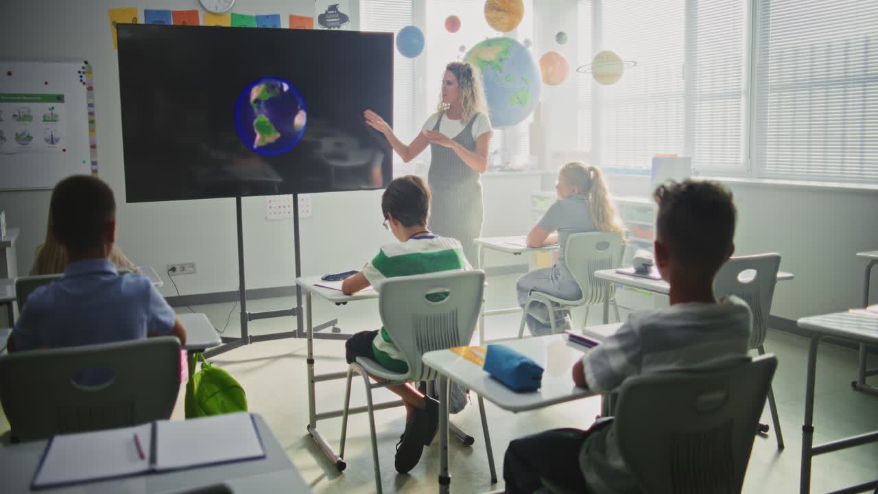 Astronomy Class Female Teacher Explaining Solar System to Primary School Children Using Digital