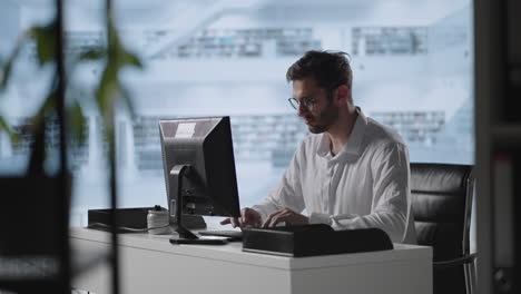 Hombre-De-Negocios-Trabajando-En-La-Computadora-En-La-Oficina-Del-Hogar.-Profesional-Masculino-Escribiendo-En-El-Teclado-De-Una-Computadora-Portátil-En-El-Lugar-De-Trabajo-De-Oficina.-Retrato-De-Un-Hombre-De-Negocios-Positivo-Mirando-La-Pantalla-Del-Portátil-En-El-Interior