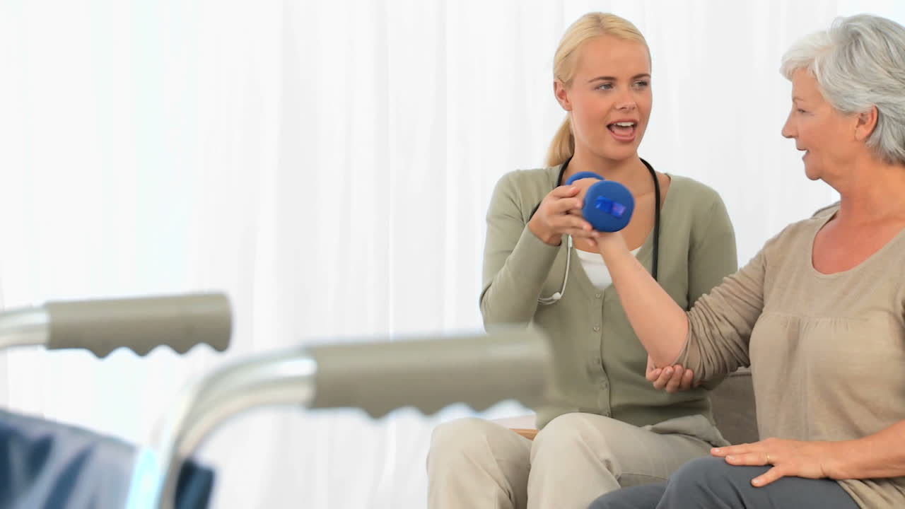 노인 여성 이 운동 을 할 수 있도록 돕는 간호사