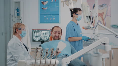 Patient-holding-mirror-to-see-teeth-alignment-after-dental-procedure