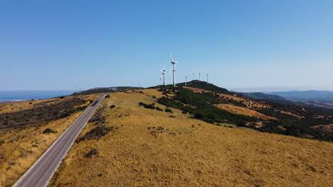 A-drone-pulls-back-from-the-wind-turbines-on-a-mountain-near-Estepona,-Spain