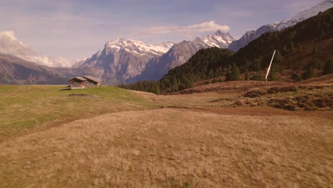 aerial drone footage pushing in over alpine meadows revealing views of wetterhorn in the swiss alps