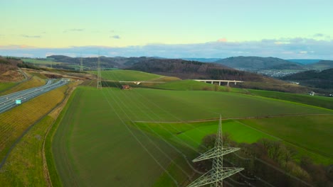 aerial view of powerlines connecting german power grid with the sauerland, germany next to autobahn 46