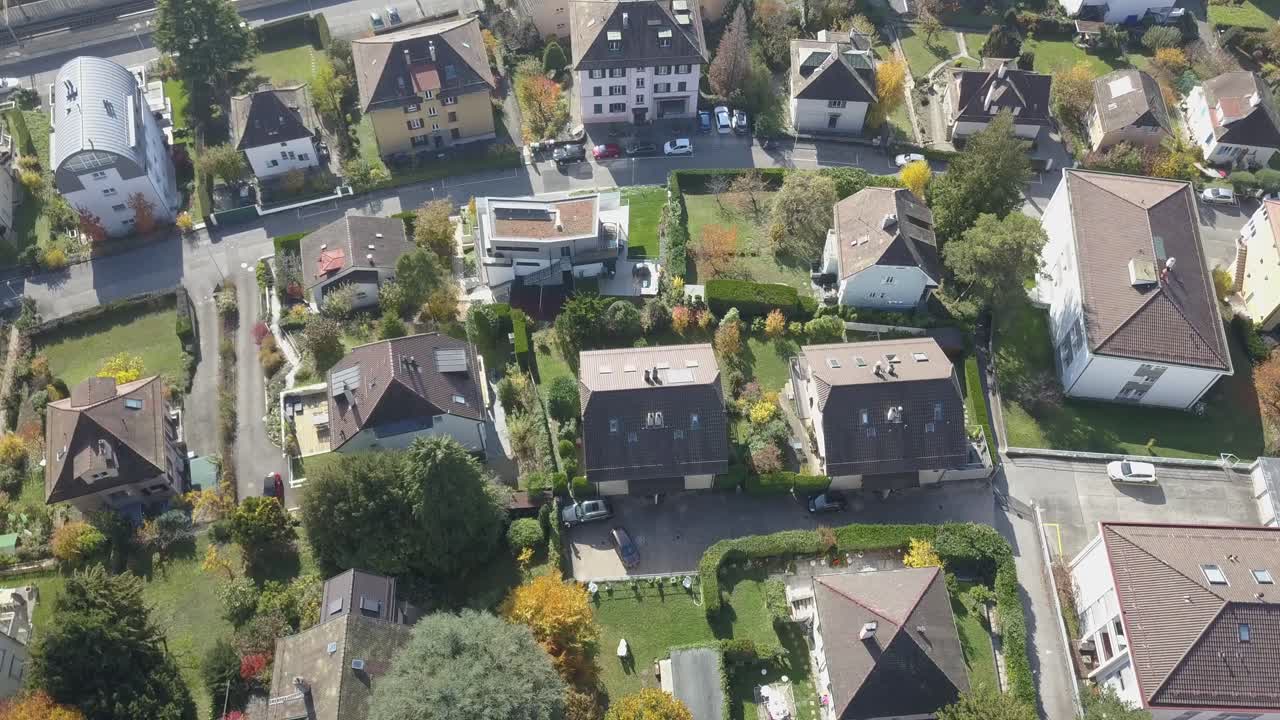 Nedadgående tilt: droneoptagelse fra luften af boliger og træer i Lausanne, hovedstaden i Vaud, Schweiz.