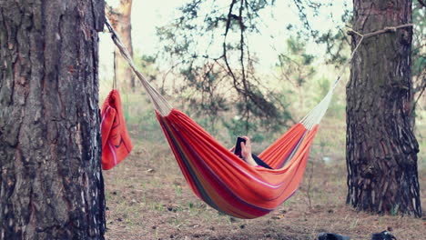 Hamaca-Relajarse.-Mujer-Joven-Usando-Un-Teléfono-Inteligente-En-Una-Hamaca-En-El-Bosque