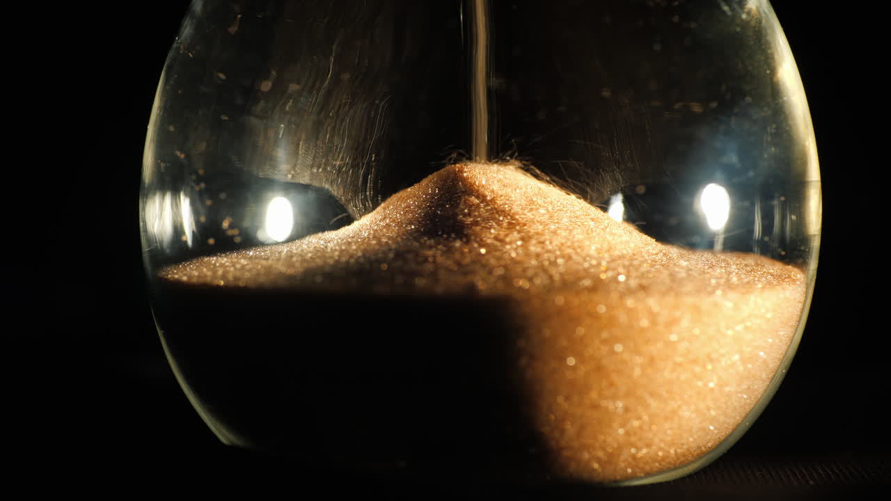 모래알이 떨어지는 둥근 모래시계 플라스크