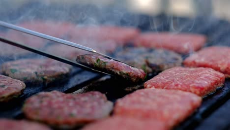 Die-Auf-Dem-Grill-Gegarten-Fleischbällchen-Werden-Mit-Einer-Zange-Aus-Nächster-Nähe-Gewendet