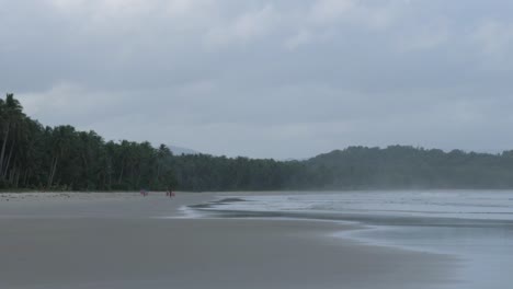 Zeitlupenaufnahme-Eines-Breiten-Und-Langen-Sandstrandes-Mit-Palmen-Und-Bewölktem-Himmel-In-Asien