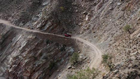 jeep driving on narrow mountain road on the way to fairy meadows, pakistan