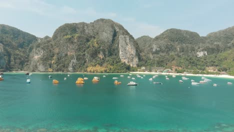 Bahía-De-Tonsai-Paraíso-Exótico-Virgen-Que-Alberga-Una-Flota-De-Botes-Pequeños-En-La-Isla-De-Ko-Phi-Phi-Don,-Tailandia---Toma-Aérea