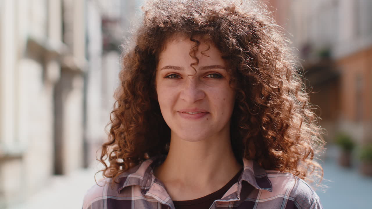 feliz mujer joven sonriendo mirando lejos soñando descansando buenas noticias sentirse satisfecho en la calle de la ciudad