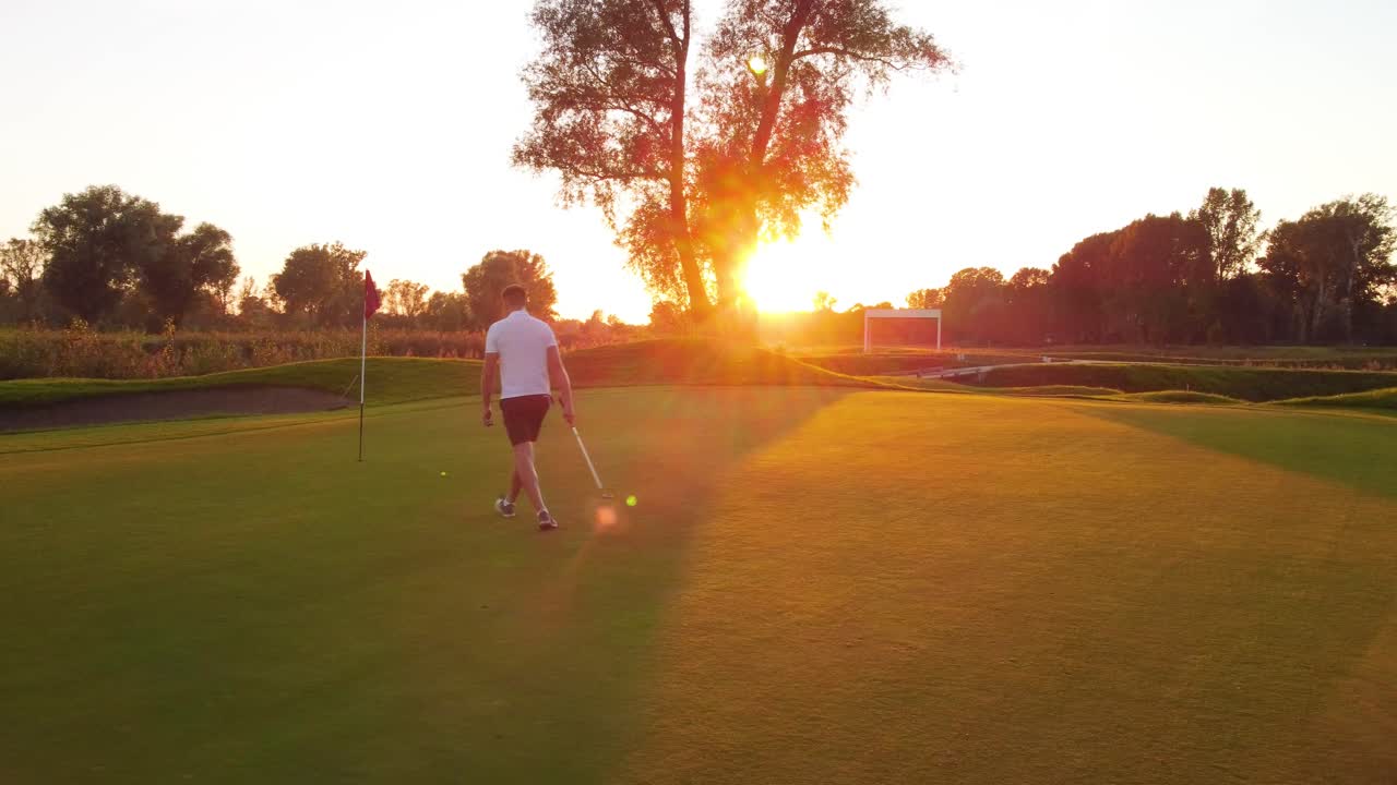 la última puesta en el green por un golfista en el campo de golf durante una puesta de sol soleada