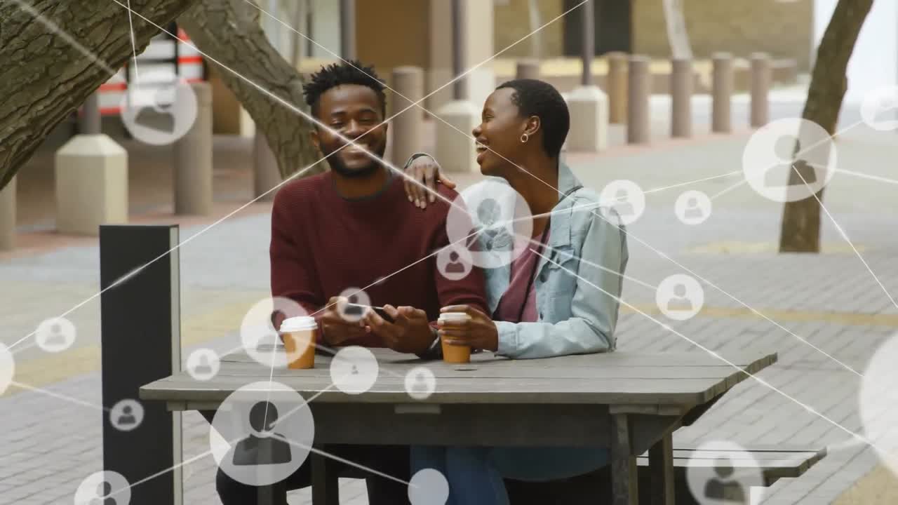Animation of a network of connections with people icons over African American couple laughing