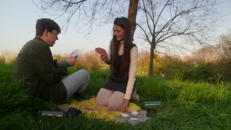couple playing cards in a park