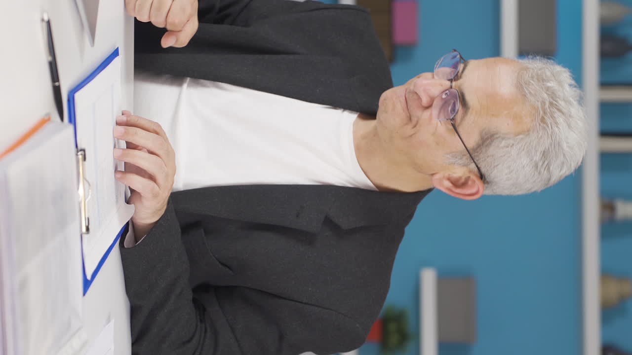 vídeo vertical de un trabajador de la oficina en casa enojándose.