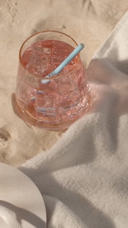 Vertical-Video-Summer-Holiday-Concept-Of-Flip-Flops-With-Cold-Drink-On-Sand-Background-With-Tree-Shade-Shadow-2