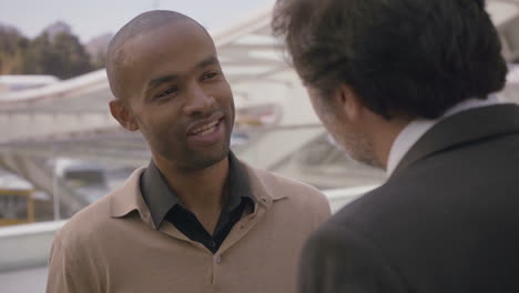 smiling african american manager having meeting with colleague in city